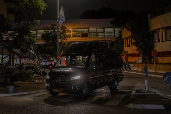 A person drives a fan with people through a street at night.